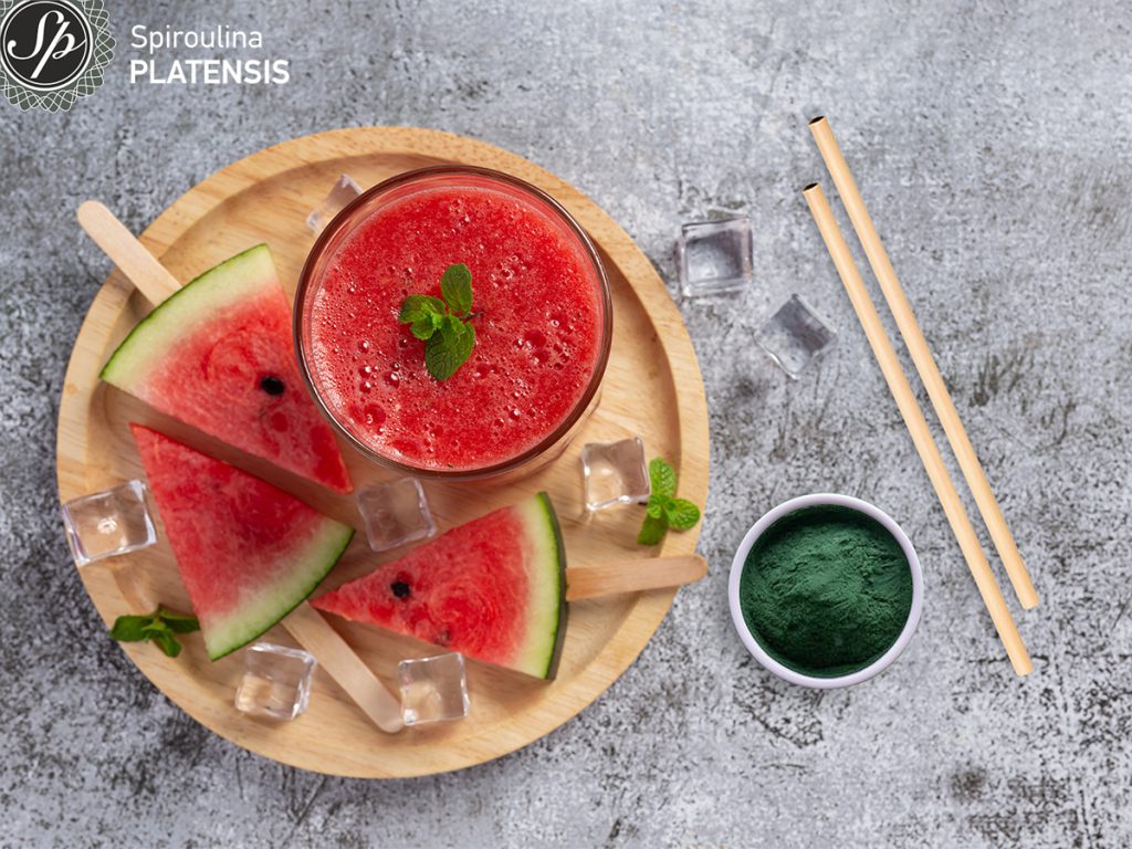 cold watermelon smoothie dark background spiroulina platensis flakes bamboo straw