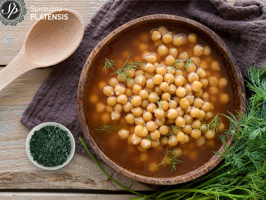 chickpeas soup with spiroulina platensis flakes in coconut vegan bowl
