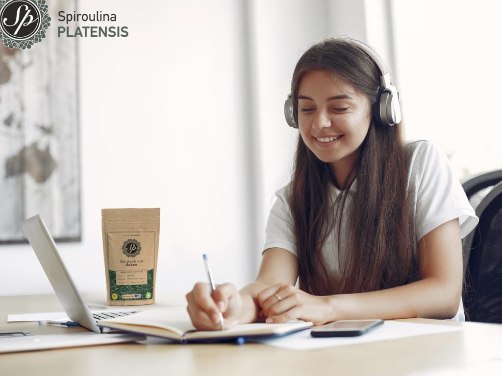 young student sitting table use laptop spiroulina platensis flakes