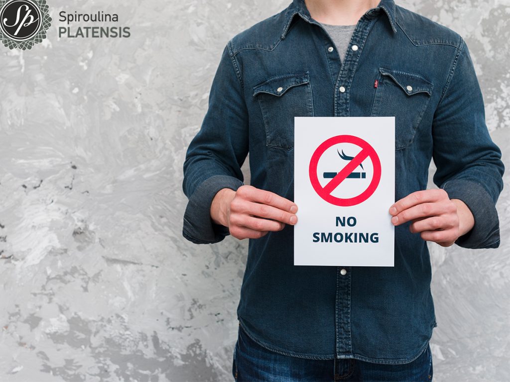 5 reasons to quit smoking TODAY! young man holding no smoking text sign poster old wall site