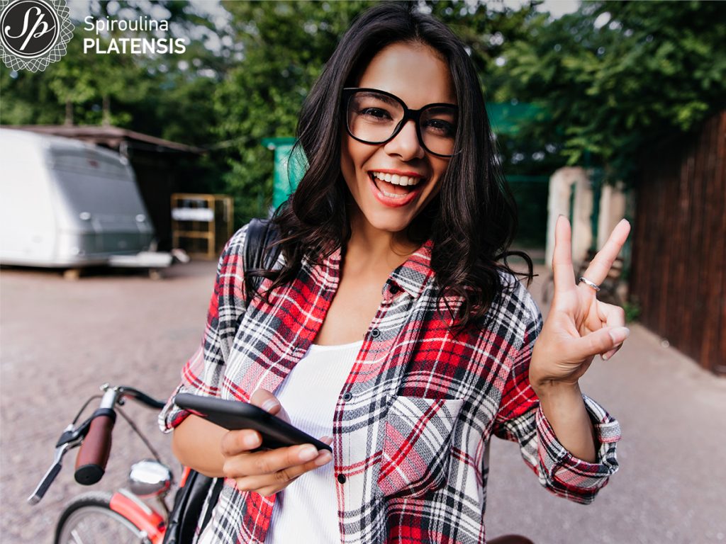 glad white girl glasses expressing positive emotions while chilling city site