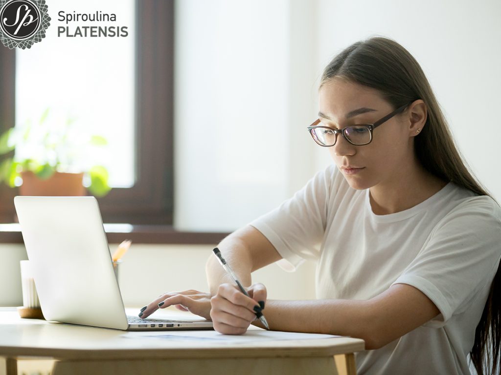 serious student working laptop preparing exams site